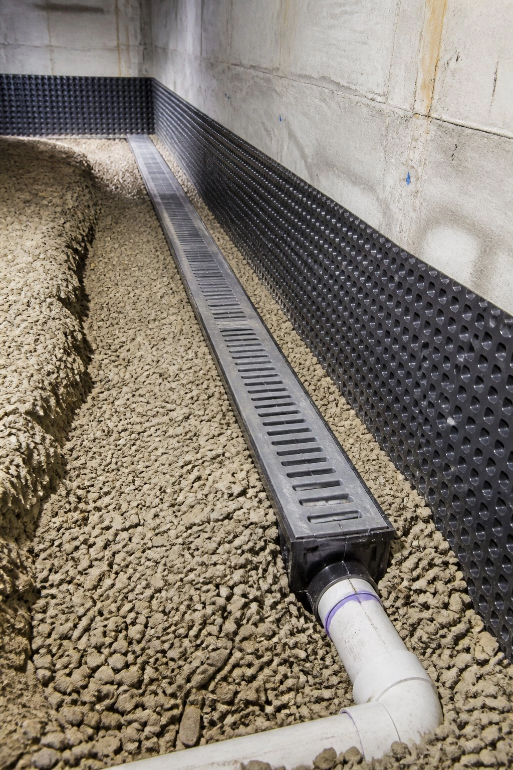 French drain and dimpled membrane installed along foundation wall