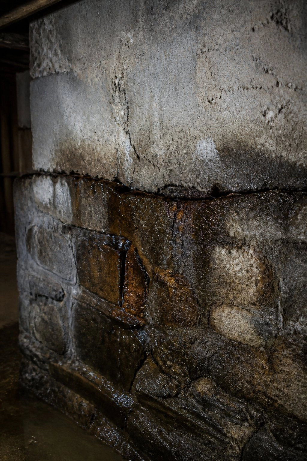 Active water leak through foundation crack on brick wall