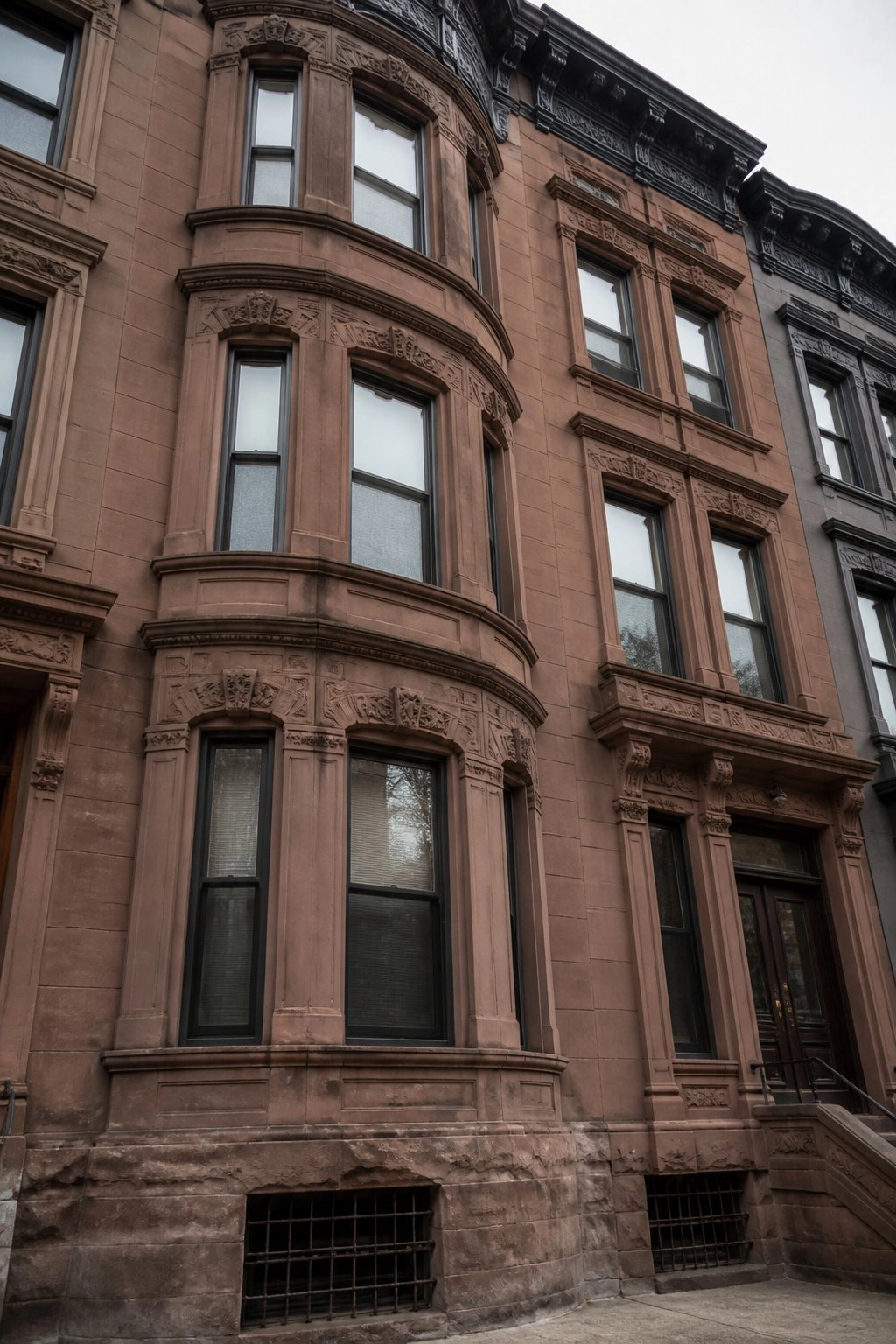 Ornate brownstone bay window facade on NYC townhouse