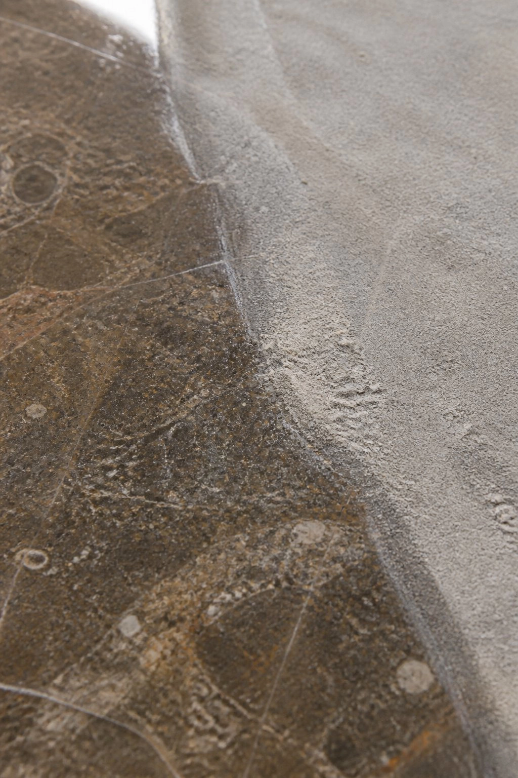 Weathered stone surface transitioning to freshly repaired patch